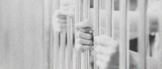 Hands on prison bars