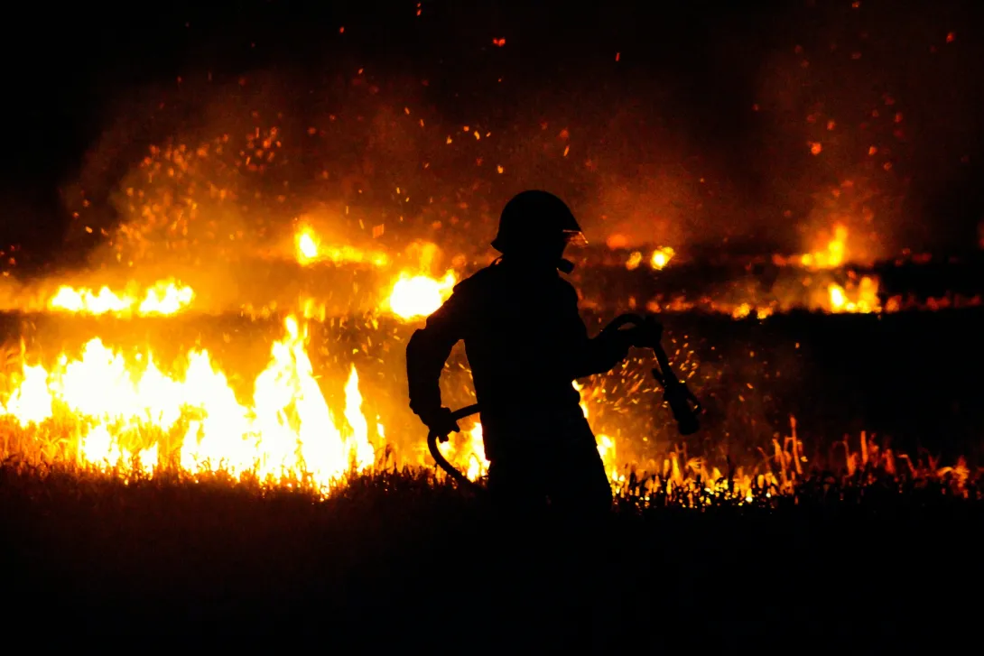 Silhouette of a firefighter in front of flames